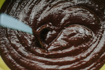  liquid chocolate dough in a spoon. mixing chocolate cake dough