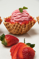 Helado de fresa con pedazos de fruta en canasta de cono