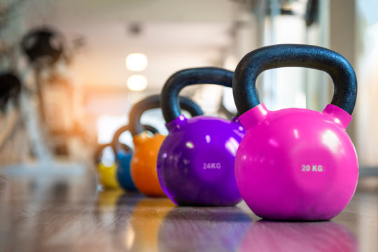 Colorful kettlebells in a gym, pink , violet, orange, blue, yellow.