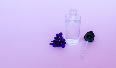 liquid in  transparent bottle with pipette for soaring electronic cigarettes with  scent and taste of flowers, on  pink background with space for text.
