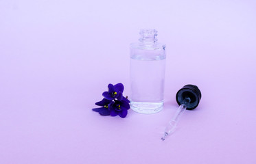 liquid in  transparent bottle with pipette for soaring electronic cigarettes with  scent and taste of flowers, on  pink background with space for text.