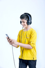 young indian cute boy listening music in headphone