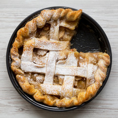 Home-baked apple pie on a white wooden surface, top view. Close-up. Flat lay, overhead, from above.
