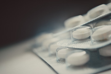 Close-up of white pills in pack. White pills in a transparent package with a blurred background.