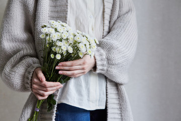 photo of young woman holding white flowers with green stem in her hands - 276648567