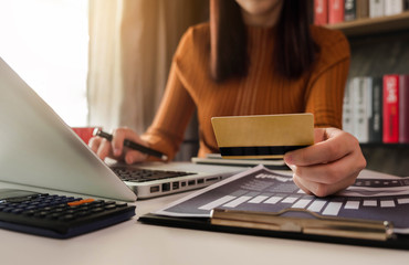 Fototapeta premium Business woman use credit card to shopping online in internet website shop with computer laptop on work table in office.