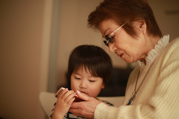 スマートフォンを使う男の子とシニア女性