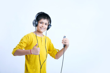 young indian cute boy listening music in headphone