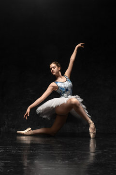 Ballerina. A young graceful ballerina dressed in professional attire, pointe shoes with ribbons and a white tutu, demonstrates dance skills. Beautiful classic ballet. Volumetric photos 3D.
