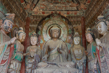 Color sculpture of Buddha and Bodhisattvas with colorful fresco in a niche within a grotto at Mount Maiji or Maijishan Grottoes, Tianshui, Gansu, China. Constructed from late fourth century CE.