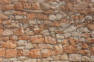 The wall of oval cobblestone color red and orange color, background texture.