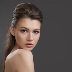 Obraz premium Beauty brunette woman with perfect makeup and skin. Beautiful professional holiday makeup, nude. Beauty girl face on dark background