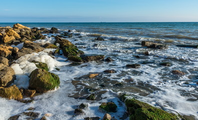 Sea foam and stones on the shore