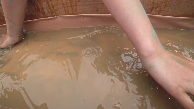 Search for gold in the gutter with running water with a high concentration of precious metal sand. Young hands carefully grope grains.