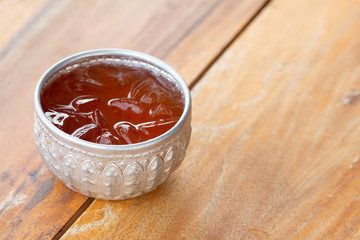 A vintage cup of iced tea on wooden table, summer drink
