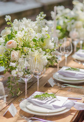 Close-up Decorative festive wooden table in vases flowers and candles for guests at a Wedding or a birthday party