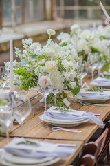 Beautiful composition with flowers on the tables and candles for guests at a wedding or a birthday party