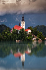 Obraz premium Lake Bled, Slovenia - Morning view of Lake Bled (Blejsko Jezero) with the Pilgrimage Church of the Assumption of Maria on a small island and Julian Alps covered by clouds