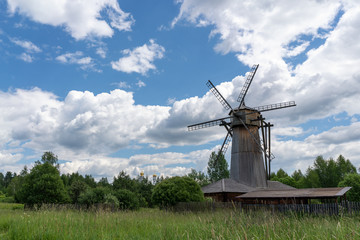 Old wooden windmill in a clearing near the forest.