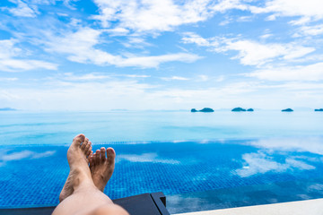 Fototapeta na wymiar Beautiful outdoor swimming pool with sea ocean on white cloud blue sky background