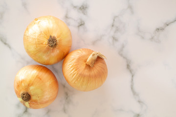 Fresh bulbs of onion on marble table