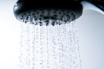 Fototapeta na wymiar Falling water drops and shower head.