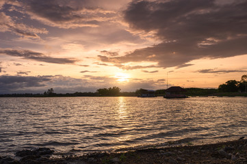 Sunset shining on Huai Mai Teng reservoir with rippled wave