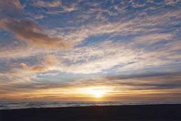 Fototapeta premium Sunrise over the sea at Diamond Beach with black lava sand at Jökulsarlon in Iceland