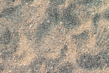 Beach sand. The texture of small stones and sand. Can be used as a texture, background or wallpaper