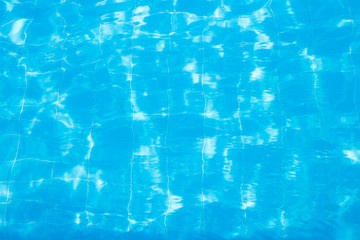 Water vibrations in the swimming pool with sun reflection. blue swimming pool surface, water background in swimming pool. Flat lay, top view