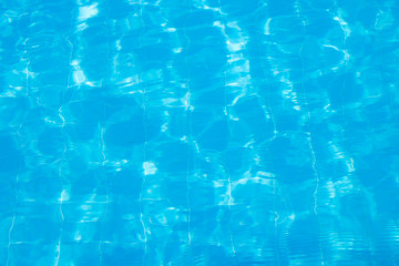 Water vibrations in the swimming pool with sun reflection. blue swimming pool surface, water background in swimming pool. Flat lay, top view