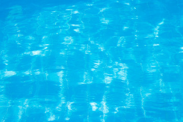 Water vibrations in the swimming pool with sun reflection. blue swimming pool surface, water background in swimming pool. Flat lay, top view