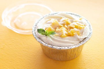 Summer fruit dessert is Mango cheesecake on yellow table background