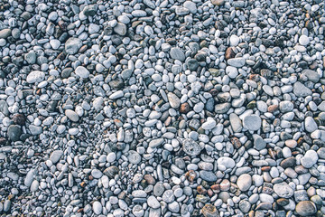 Beach stone pebbles. The texture of small stones and sand. Can be used as a texture, background or wallpaper