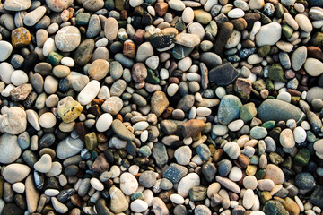 Beach stone pebbles. The texture of small stones and sand. Can be used as a texture, background or wallpaper