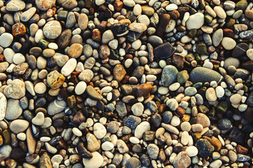 Beach stone pebbles. The texture of small stones and sand. Can be used as a texture, background or wallpaper