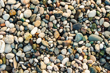 Beach stone pebbles. The texture of small stones and sand. Can be used as a texture, background or wallpaper