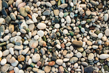 Beach stone pebbles. The texture of small stones and sand. Can be used as a texture, background or wallpaper
