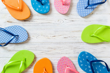 a lot of flip flop colored sandals, summer vacation on wooden background, copy space top view