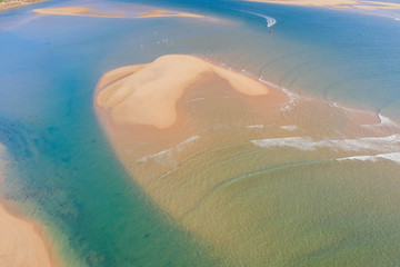 Top beautiful view of a beach at sunrise with beautiful waves lines, shallow turquoise water
