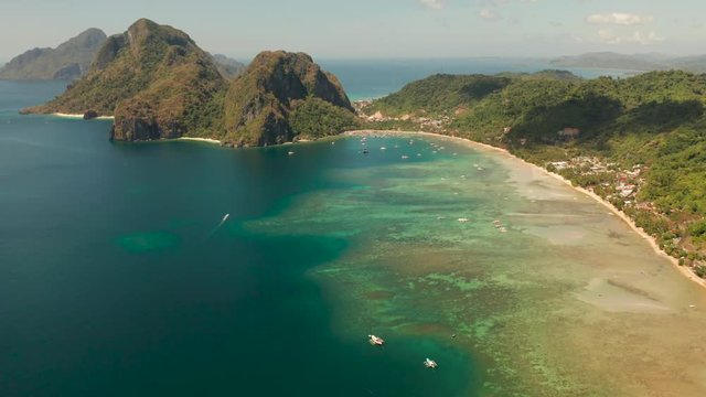 Aerial view bay with lagoon and turquoise water on a tropical island against the backdrop of the mountains. Corong corong beach, El Nido, Palawan, Philippines. Summer and travel vacation concept
