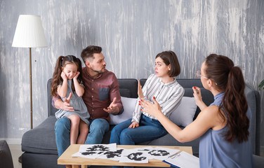Unhappy family visiting psychologist in office