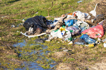 Pile of garage on green grass in the nature environment problems. Nature protection.