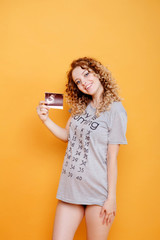 pregnant young beautiful fashion blonde model woman in studio holds ultrasound test on yellow orange background smilles