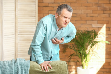 Mature man suffering from heart attack at home