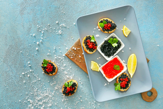 Composition with black and red caviar on color background