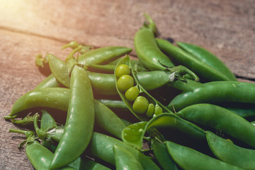 Fresh green peas or beans on wooden table