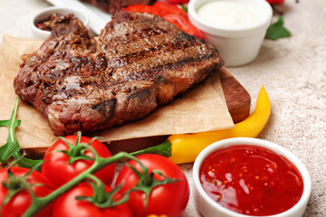 Tasty grilled meat with vegetables on table, closeup