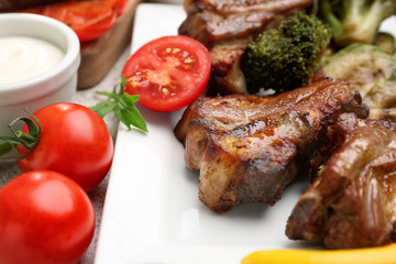 Tasty grilled meat with vegetables on plate, closeup