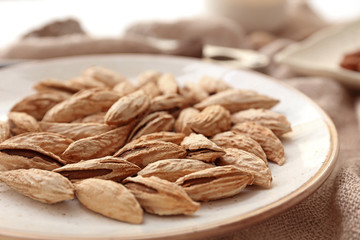 Plate with almonds on table, closeup